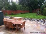 Patio installed with 4 size sawn sandstone paving edged with firestone rocks and alpine planting, steps built with sawn sandstone uprights and sawn sandstone bullnose treads