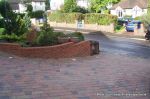 Driveway installed with Tegula paving laid at 45 degree to property with in set lighting and feature wall merging into timber wall along front garden and road boundary