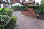 Driveway installed with Tegula paving laid at 45 degree to property with in set lighting and feature wall merging into timber wall along front garden and road boundary