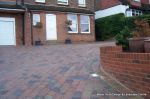 Stepped red brick wall with built in bin cupboard 