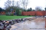 Patio installed with 4 size sawn sandstone paving edged with firestone rocks and alpine planting, steps built with sawn sandstone uprights and sawn sandstone bullnose treads