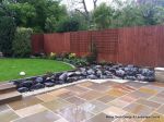 Patio installed with 4 size sawn sandstone paving edged with firestone rocks and alpine planting, steps built with sawn sandstone uprights and sawn sandstone bullnose treads