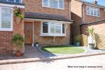 AFTER: Driveway installed with Tegula paving with added jumper block, kerbs installed to retain split levels and feature circle lawn and fencing installed. 