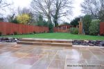 Tired garden received a complete new design Patio installed with 4 size sawn sandstone paving edged with firestone rocks and alpine planting, steps built with sawn sandstone uprights and sawn sandstone bullnose treads, New lawn installed in 3 rings all ed