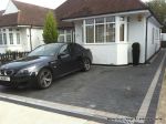 New driveway installed using granite paving with contrasting colour band and inset lights