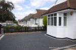 New driveway installed using granite paving with contrasting colour band and inset lights