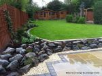 Patio installed with 4 size sawn sandstone paving edged with firestone rocks and alpine planting, steps built with sawn sandstone uprights and sawn sandstone bullnose treads