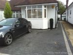 New driveway installed using granite paving with contrasting colour band and inset lights