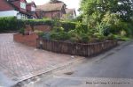 Driveway installed with Tegula paving laid at 45 degree to property with in set lighting and feature wall merging into timber wall along front garden and road boundary