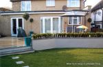 Garden was very unusable with Multiple steps from back doors new deck with inset sandstone sunflower feature was installed with new block rendered planter wall planted with topiary and linking circle lawns edged with granite setts and separate children's 