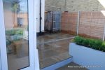 patio was constructed useing fossil sandstone in 4 sizes laid to a random pattern with a curved block planter wall painted in gun ship grey and planted with a topiary hedge.