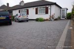 New driveway installed using granite paving with contrasting colour band and inset lights