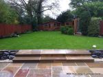 Patio installed with 4 size sawn sandstone paving edged with firestone rocks and alpine planting, steps built with sawn sandstone uprights and sawn sandstone bullnose treads