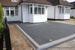 New driveway installed using granite paving with contrasting colour band and inset lights