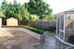 patio was constructed useing fossil sandstone in 4 sizes laid to a random pattern with a curved block planter wall painted in gun ship grey and planted with a topiary hedge.