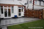 New Granite patio and path installed with contrasting dark colour band, New lawn, fencing and planting installed